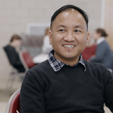 Refugee smiling and talking to ESL teacher.